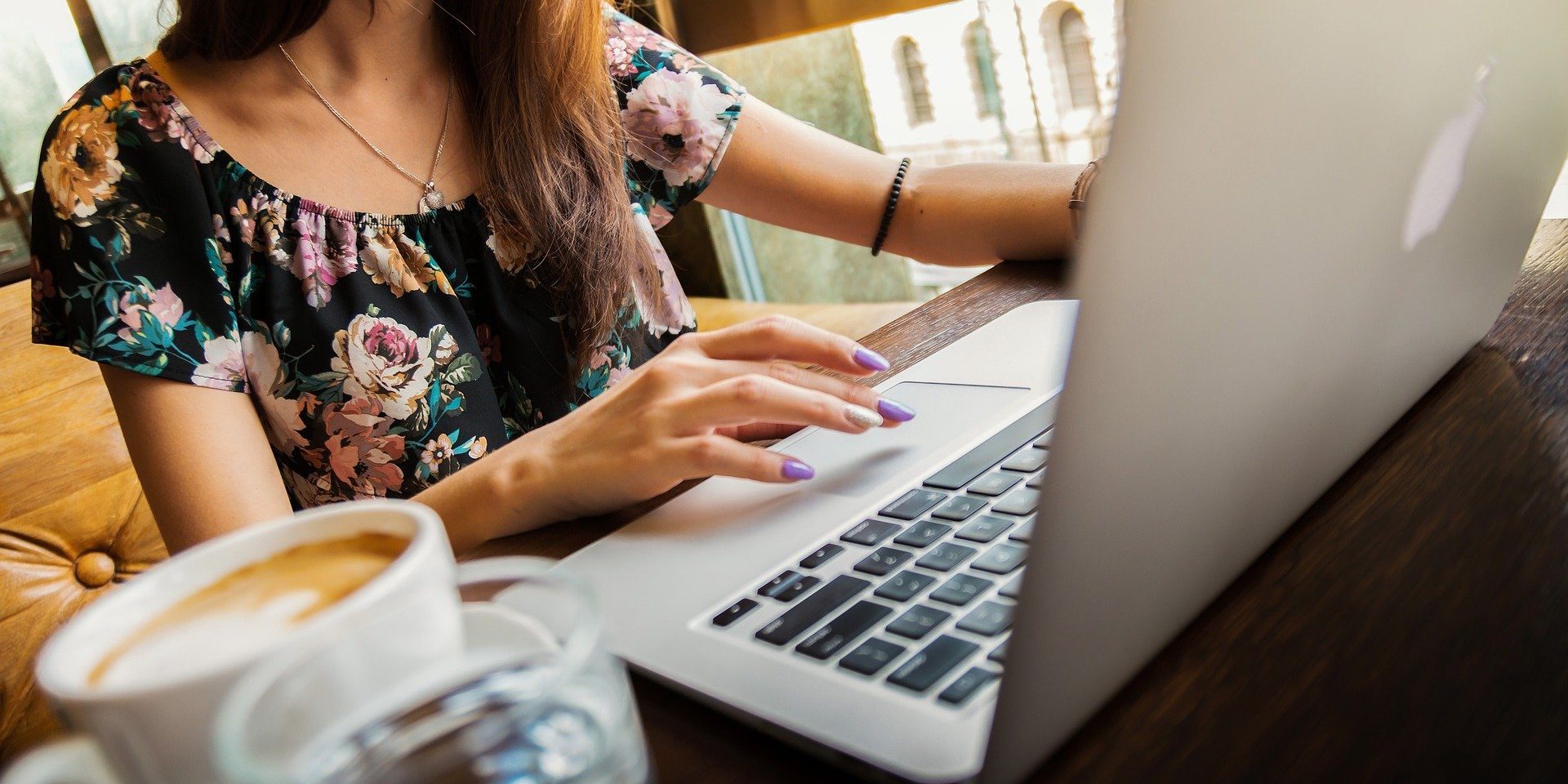 Woman at laptop with coffee next to her