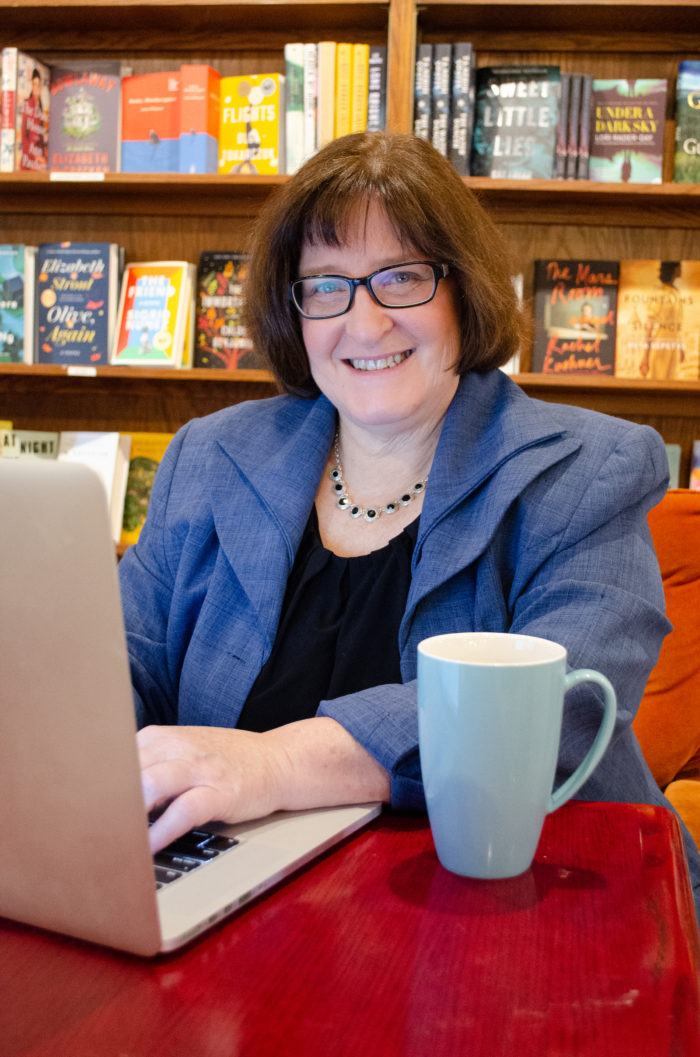 Nancy at computer in bookstore/cafe with a cup of tea